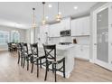 Bright kitchen features a spacious island with seating, modern appliances, and elegant pendant lighting at 4056 Burdick Loop, Odessa, FL 33556