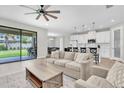 Open-concept living space with a modern kitchen, comfortable seating, and sliding glass doors to the patio at 4056 Burdick Loop, Odessa, FL 33556