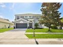 Beautiful two-story home with a well-maintained lawn, two-car garage, and a lovely tree in the front yard at 4094 Braemere Dr, Spring Hill, FL 34609