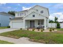 Well-maintained two-story home with inviting porch seating and a lush, green lawn at 4215 Maplehurst Way, Spring Hill, FL 34609