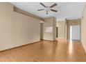 Spacious living room featuring wood floors, a ceiling fan, and ample natural light at 4221 San Rafael Ave, New Port Richey, FL 34655