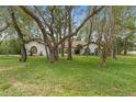 This property boasts a well-maintained lawn, mature trees, and attractive architectural details at 4595 Lake In The Woods Dr, Spring Hill, FL 34607