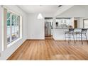 Bright, open-concept living space with hardwood floors and stainless steel kitchen appliances in background at 6197 Belkton Ave, Spring Hill, FL 34608