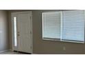Bright entryway featuring a white front door and a window with blinds at 6406 Stone Rd, Port Richey, FL 34668