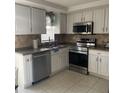 Updated kitchen with stainless steel appliances and white cabinets, seamlessly combining style and functionality at 6603 Adams St, New Port Richey, FL 34652