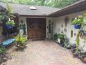Inviting front entrance with double doors, surrounded by colorful plants and unique decorations at 7323 Ray Browning Rd, Brooksville, FL 34601