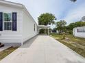 Side view of a single-story home with a long, concrete driveway and carport at 7353 Thorpp Ave, Brooksville, FL 34613