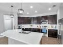 Modern kitchen featuring dark cabinetry, stainless steel appliances, a kitchen island, and recessed lighting at 7523 Tangle Brook Blvd, Gibsonton, FL 33534