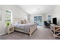 Bright bedroom with neutral colors, ensuite desk and sliding glass doors leading to a pool at 8084 Nightingale Rd, Weeki Wachee, FL 34613