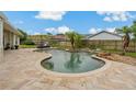 Backyard in-ground pool with a brick patio, surrounded by a wooden fence and lush greenery at 8850 March Ct, New Port Richey, FL 34655