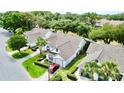 Aerial view of homes with well-manicured lawns, mature trees, and a red car parked in the driveway at 9200 Turnberry Ct, New Port Richey, FL 34655