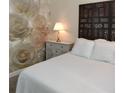 Inviting bedroom featuring a decorative headboard, wallpaper accent wall, and plush pillows at 9967 Patrician Dr, New Port Richey, FL 34655