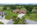 Aerial view of a beautiful house with a manicured lawn and an extra large concrete driveway at 10044 Twelve Oaks Ct, Weeki Wachee, FL 34613