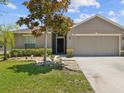 Inviting home entrance with a well-maintained lawn, stone landscaping and modern front door at 10120 Ives Loop, Hudson, FL 34667