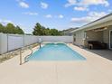 Backyard featuring a sparkling blue swimming pool, fenced-in area, and covered patio for relaxation at 10120 Ives Loop, Hudson, FL 34667