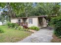 Quaint single-story home featuring front porch, complemented by mature trees and side driveway at 10149 Huntley St, New Port Richey, FL 34654
