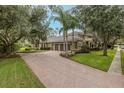 Expansive brick driveway leading to a three-car garage complements the home's exterior at 10531 Pontofino Cir, Trinity, FL 34655