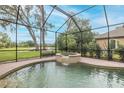 Screened-in pool area featuring a relaxing in-ground spa, surrounded by lush greenery at 10531 Pontofino Cir, Trinity, FL 34655