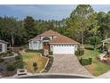 Inviting single-story home with brick paver driveway and lush landscaping at 11404 Inman Ct, Spring Hill, FL 34609