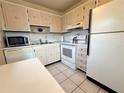 Classic kitchen features white appliances, ample cabinetry, and a clean, functional layout for easy meal preparation at 11733 Bayonet Ln, New Port Richey, FL 34654