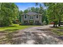 A charming home featuring a two-story exterior elevation, a front yard and luscious surrounding trees at 12085 Stringer Rd, Brooksville, FL 34601