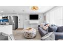 Inviting living room with gray sofas and a view into the kitchen at 12535 Third Isle, Hudson, FL 34667