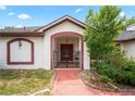 Arched entryway features a red walkway and double doors, creating a welcoming entrance at 128 Oak Lake Dr, Spring Hill, FL 34608