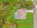 Aerial view of a property with a large lot, mature trees, and a private screened-in pool at 12805 Coronado Dr, Spring Hill, FL 34609