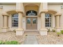 Elegant front entrance with decorative columns and a custom-designed double-door entry at 12805 Coronado Dr, Spring Hill, FL 34609