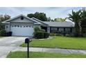 Charming single-story home with a two car garage, manicured lawn, and mature landscaping at 13316 Brigham Ln, Hudson, FL 34667