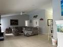 Spacious living room with high ceilings, tile floors, ceiling fan, and modern décor at 13316 Brigham Ln, Hudson, FL 34667