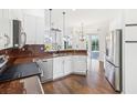 Modern kitchen with stainless steel appliances, white cabinetry, and hardwood floors, offering a sleek design at 13922 Talmage Loop, Hudson, FL 34667