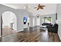 View of the open floor plan that flows to the kitchen, offering abundant natural light and a ceiling fan at 2172 Whitewood Ave, Spring Hill, FL 34609