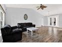 The living room offers vaulted ceilings, wood floors, a ceiling fan, and lots of natural light at 2172 Whitewood Ave, Spring Hill, FL 34609