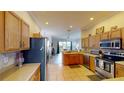 Open kitchen featuring wooden cabinets, stainless steel appliances, and seamless flow to living area at 22316 Red Jacket Ln, Land O Lakes, FL 34639