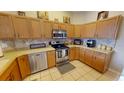 Well-lit kitchen with wooden cabinets, stainless steel appliances, and tile flooring at 22316 Red Jacket Ln, Land O Lakes, FL 34639