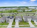 Aerial view of a residential area featuring houses, green spaces, a pool, and a community center at 2572 Garden Plum Pl, Odessa, FL 33556