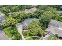 An aerial view of the home with stone accents, a lush landscape, and mature trees at 2880 Chelsea N Pl, Clearwater, FL 33759
