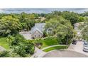 An elevated view of a home's landscaped yard, stone accents, and mature trees at 2880 Chelsea N Pl, Clearwater, FL 33759