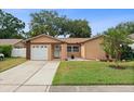 Charming single-story home featuring a well-manicured lawn and inviting curb appeal, complete with an attached garage at 2887 Cathy Ln, Clearwater, FL 33760
