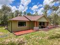 A lovely single story home featuring green stucco and a well-manicured lawn at 34335 Berryhill Dr, Webster, FL 33597