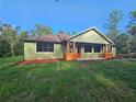 A quaint, single-story home with a warm, inviting red door and pretty flower boxes on the front porch at 34335 Berryhill Dr, Webster, FL 33597