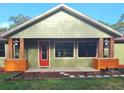 Single-story home with a new roof, a bright red front door, and delightful flower box accents on the porch at 34335 Berryhill Dr, Webster, FL 33597