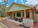 Inviting front porch with wooden beams and stylish seating at 34335 Berryhill Dr, Webster, FL 33597