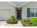 Inviting front entrance with colorful flowers and decorative wreath that enhances the home's charm and character at 3900 Autumn Amber Dr, Spring Hill, FL 34609