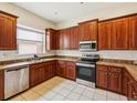 Well-lit kitchen with wood cabinets, stainless steel appliances and granite counters at 4266 High Ridge Ave, Spring Hill, FL 34609