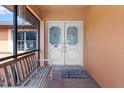 Welcoming front porch with a bench, a 'welcome' mat and double doors with decorative glass panels at 4289 Castle Ave, Spring Hill, FL 34609