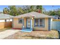 Charming single-story home featuring a blue and yellow color scheme and a well-manicured front lawn at 4503 Courtland St, Tampa, FL 33610
