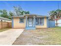 Charming single-story home featuring a blue and yellow color scheme and a well-manicured front lawn at 4503 Courtland St, Tampa, FL 33610