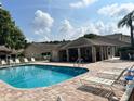 Enjoy this refreshing community pool surrounded by lounge chairs and a covered seating area for relaxing outdoors at 4557 Glen Holw, New Port Richey, FL 34653